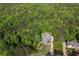 Aerial view of a home nestled among large trees with lush foliage and a long winding driveway at 313 Red Fox Dr, Canton, GA 30114