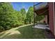 Expansive backyard with lush green grass, surrounded by mature trees, view from covered patio at 313 Red Fox Dr, Canton, GA 30114