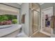 Bright bathroom featuring a soaking tub with a backyard view and a glass-enclosed shower at 313 Red Fox Dr, Canton, GA 30114