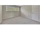 Empty bedroom with neutral carpet, three windows providing natural light, and a white door at 313 Red Fox Dr, Canton, GA 30114