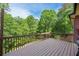 Wooden deck featuring a railing and view of the green backyard surrounded by mature trees at 313 Red Fox Dr, Canton, GA 30114
