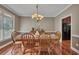 Elegant dining room featuring a chandelier, hardwood floors, and a view into kitchen at 313 Red Fox Dr, Canton, GA 30114