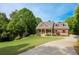 Charming two-story red home featuring a well-manicured lawn, porch, and long driveway at 313 Red Fox Dr, Canton, GA 30114