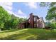 Rear exterior of a two-story home with a chimney, outdoor deck, and luscious green lawn at 313 Red Fox Dr, Canton, GA 30114