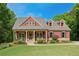Inviting two-story home featuring a covered front porch, landscaped yard and a symmetrical facade at 313 Red Fox Dr, Canton, GA 30114
