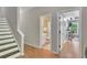 Hallway featuring stairs, wood floors, and doorways to a bathroom and office space at 313 Red Fox Dr, Canton, GA 30114