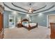 Main bedroom featuring a tray ceiling, wood furniture, and a view to the ensuite bathroom at 313 Red Fox Dr, Canton, GA 30114