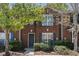 Lovely brick townhome showcasing well-maintained landscaping, large window, and dark shutters at 3149 Kingswood Gln, Decatur, GA 30034