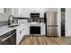 Modern kitchen featuring stainless steel appliances, white cabinetry, and wood flooring at 3149 Kingswood Gln, Decatur, GA 30034