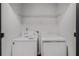 Laundry room with a front loading washer and dryer, and a wire shelf above at 3149 Kingswood Gln, Decatur, GA 30034