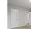 An empty bedroom showcases neutral walls, plush carpeting, and multiple white doors at 3573 Stonebranch Ln, Loganville, GA 30052