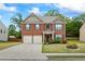 Inviting two-story brick home with a well-manicured lawn and a two-car garage at 3573 Stonebranch Ln, Loganville, GA 30052