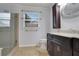 Bathroom featuring a dark vanity, shower, window, and decorative oval mirror at 4535 Clipper Bay Rd, Duluth, GA 30096