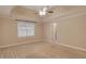 Neutral carpeted main bedroom with a large window and a ceiling fan at 4535 Clipper Bay Rd, Duluth, GA 30096