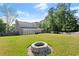 Large backyard with fire pit, lush lawn, and mature trees at 660 Cranberry Ct, Roswell, GA 30076