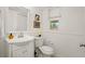 Well-lit powder room with white fixtures and wainscotting at 660 Cranberry Ct, Roswell, GA 30076