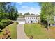Charming two-story home featuring a well-manicured lawn, attached garage, and welcoming blue front door at 660 Cranberry Ct, Roswell, GA 30076