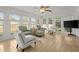 Bright sunroom with many windows, tile floors, ceiling fan and comfortable seating arrangement at 660 Cranberry Ct, Roswell, GA 30076