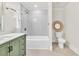 Stylish bathroom with a tub, shower, green vanity, modern fixtures, and decorative mirror at 11 Poplar St, Porterdale, GA 30014
