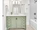 Charming bathroom with a sage vanity, decorative lighting, and a tiled shower-tub combination at 11 Poplar St, Porterdale, GA 30014