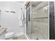 Bathroom features a white toilet and shower with mosaic tile accents and glass door at 11 Poplar St, Porterdale, GA 30014