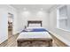 Bright bedroom with a wooden bed frame and natural light coming through the window at 11 Poplar St, Porterdale, GA 30014