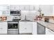 Bright kitchen with stainless steel appliances, granite countertops, stylish backsplash, and ample cabinet space at 11 Poplar St, Porterdale, GA 30014