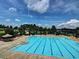Large community pool with marked lanes, a waterslide, surrounding trees and lounge chairs at 111 Churchcliff Dr, Woodstock, GA 30188
