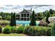 Community clubhouse and large pool with waterslide, lounge chairs, and mature landscaping at 111 Churchcliff Dr, Woodstock, GA 30188