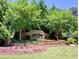 Elegant Woodlands community entrance sign surrounded by meticulously maintained landscaping and flowerbeds at 111 Churchcliff Dr, Woodstock, GA 30188