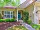 Inviting home exterior with a blue front door, lush landscaping and covered porch at 111 Churchcliff Dr, Woodstock, GA 30188