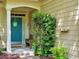 View of the home's blue front door, covered entryway, and attractive landscaping at 111 Churchcliff Dr, Woodstock, GA 30188
