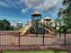 Fenced-in playground with slides, towers, bridges, and climbing wall on a mulch surface at 111 Churchcliff Dr, Woodstock, GA 30188
