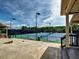 Two fenced-in tennis courts with lights, benches, and trash receptacle in a concrete space at 111 Churchcliff Dr, Woodstock, GA 30188