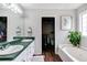 Bathroom featuring dual sinks, vanity, soaking tub, walk-in closet, and a window for natural light at 115 N Loblolly Xing, Temple, GA 30179