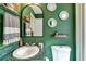 Bathroom featuring green walls, decorative mirrors, floating shelves, and a modern toilet at 115 N Loblolly Xing, Temple, GA 30179