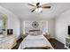 Spacious main bedroom featuring a ceiling fan, two windows, dark floors, and neutral decor at 115 N Loblolly Xing, Temple, GA 30179