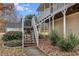Side exterior view of the stairs that lead to a covered porch of a tan home at 115 N Loblolly Xing, Temple, GA 30179