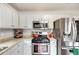 Well-lit kitchen featuring stainless steel appliances, granite countertops, and white cabinets at 115 N Loblolly Xing, Temple, GA 30179