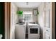 Bright laundry room with a washer, dryer, window, shelving, and laundry room decoration at 115 N Loblolly Xing, Temple, GA 30179
