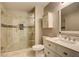 Bright bathroom with glass shower, neutral tile, and vanity with storage at 4199 Wyndham Park Way, Buford, GA 30519