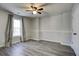 Bedroom featuring gray laminate floors, a window, and a ceiling fan for comfort at 4199 Wyndham Park Way, Buford, GA 30519