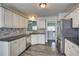 Well-lit kitchen with white cabinets, stainless steel appliances, and gray backsplash at 4199 Wyndham Park Way, Buford, GA 30519
