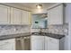 A close view of a kitchen sink with a gray backsplash and stainless steel dishwasher at 4199 Wyndham Park Way, Buford, GA 30519