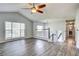 Bright living room featuring hardwood floors, a ceiling fan, and natural light from large windows at 4199 Wyndham Park Way, Buford, GA 30519