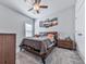 A serene bedroom featuring carpeted floors, stylish light fixture, and a comfortable bed with decorative pillows at 132 Neese Farm Dr, Woodstock, GA 30188