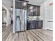 Modern kitchen featuring stainless steel refrigerator and dark cabinetry with gray toned wood flooring at 132 Neese Farm Dr, Woodstock, GA 30188