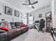 A cozy, carpeted living room featuring a sectional couch, ceiling fan, and natural light from a window at 132 Neese Farm Dr, Woodstock, GA 30188