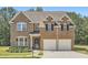 Inviting two-story brick home with a well-manicured lawn and a two-car garage at 23 Dynasty Dr, Fairburn, GA 30213