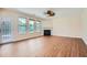 Spacious living room featuring wood floors, fireplace, ceiling fan, and door to the exterior at 23 Dynasty Dr, Fairburn, GA 30213